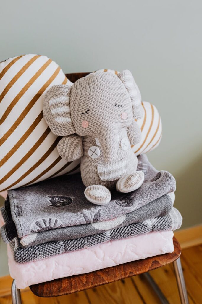 Charming baby room decor featuring a plush elephant toy and cozy textiles.